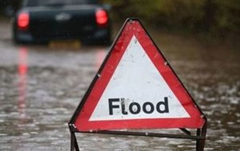 Warning sign on a flooded road.